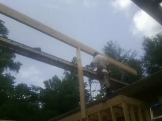Carpenter setting a ridge beam over a new addition frame — Ice Dam Removal by Roofing Brothers in Graniteville