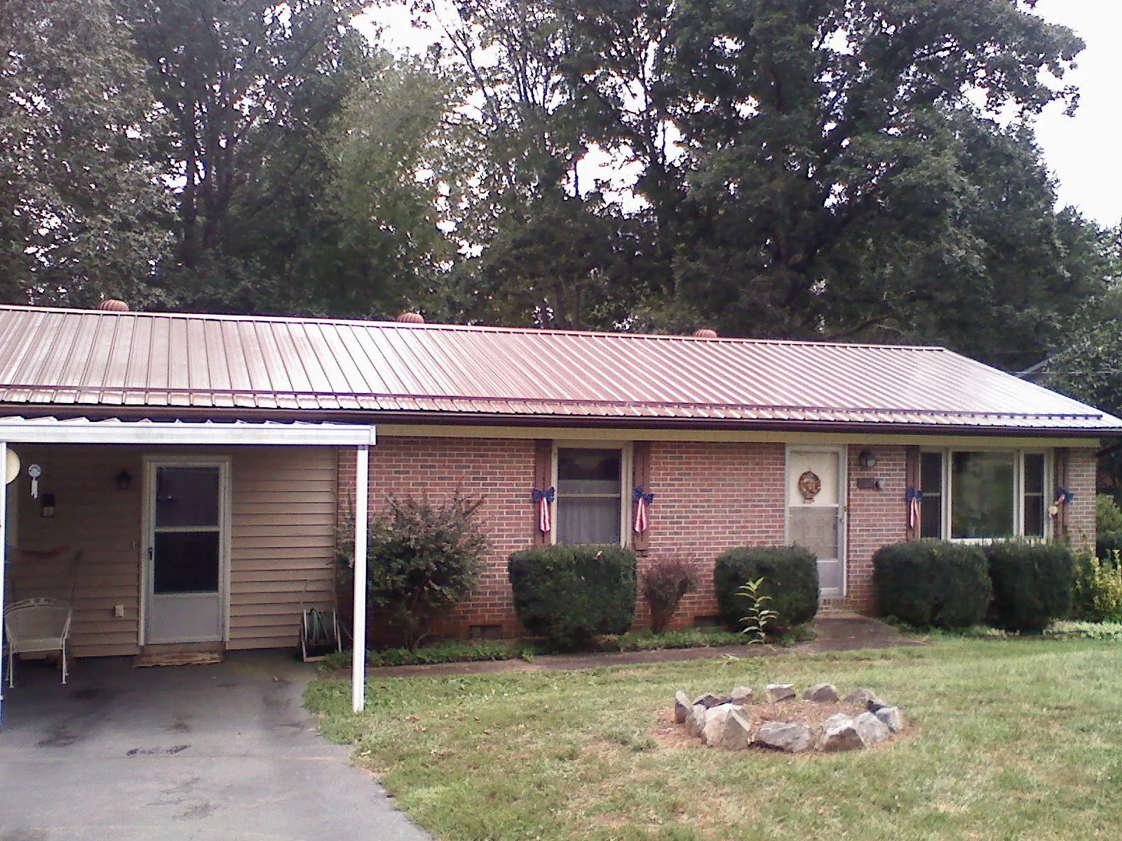 Bronze metal roof and carport on a brick ranch home — Roof Repair work by our crew in Graniteville